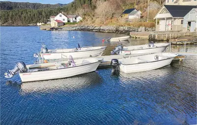three boats are docked in a body of water at Amazing Home In Nordtveitgrend in Hjartåker