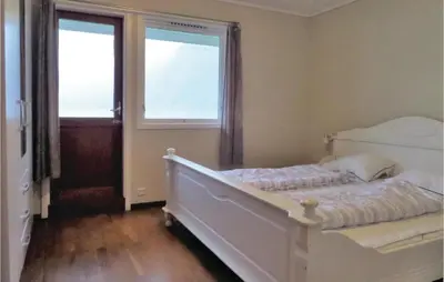 a bedroom with a white bed and two windows at Holiday Home Eidfjord Simadalsv in Eidfjord