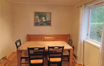 a dining room with a wooden table and chairs at Holiday Home Eidfjord Simadalsv in Eidfjord