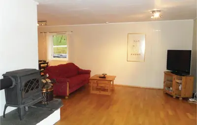 a living room with a red couch and a tv at Holiday Home Eidfjord Simadalsv in Eidfjord
