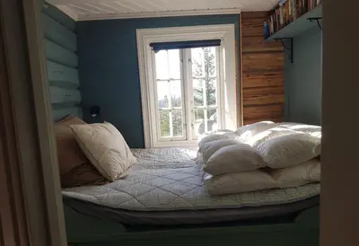 a bedroom with a bed with pillows and a window at Fredelig plass for rekreasjon in Krøderen