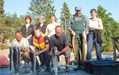 a group of people standing with fish in their hands at Nice Home In Hatlestrand in Hatlestrand