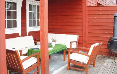 a patio with a table and chairs on a porch at 3 Bedroom Beautiful Home In Hatlestrand in Hatlestrand