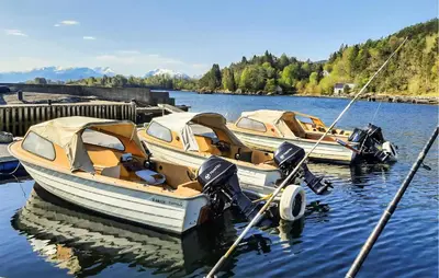 two boats are docked at a dock in the water at 3 Bedroom Beautiful Home In Hatlestrand in Hatlestrand