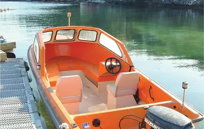 an orange boat in the water on a lake at Lovely Home In Hatlestrand With Kitchen in Hatlestrand