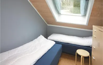 a small room with two beds and a window at Cozy Home In Hatlestrand With Sauna in Hatlestrand