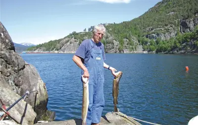 a man holding a large fish in a lake at Holiday Home Jondal Torsnes in Jondal