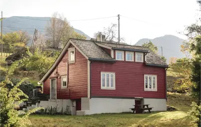 a red house with a picnic table in front of it at Holiday Home Jondal Torsnes in Jondal