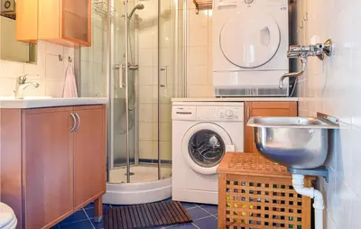 a bathroom with a shower and a washing machine at Stunning Home In Os With Kitchen in Oma
