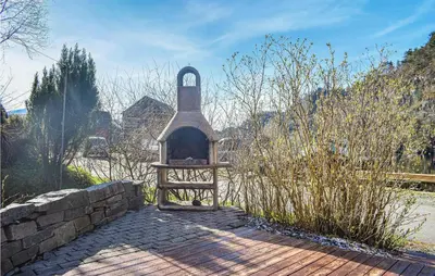 a small oven in a garden with a stone wall at Stunning Home In Os With Kitchen in Oma