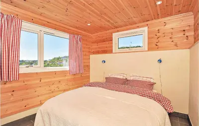 a bedroom with a bed in a wooden room at Cozy Apartment In Straumsgrend in Bergen