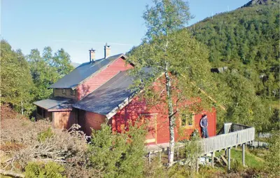 a man standing in front of a red house at Holiday Home Tysse Eikedal in Tysse