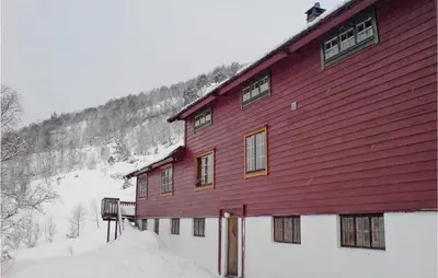 a large red building with snow around it at Holiday Home Tysse Eikedal in Tysse
