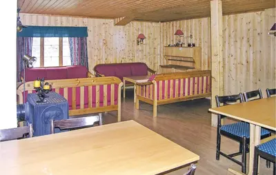 a living room with tables and chairs and a stove at Holiday Home Tysse Eikedal in Tysse
