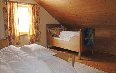 a bedroom with two beds and a window at Holiday Home Evanger Brekkhuslii in Evanger