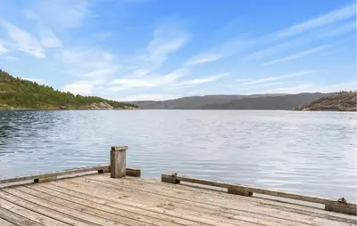 a dock on a lake with mountains in the background at Sørkvingo in Masfjorden