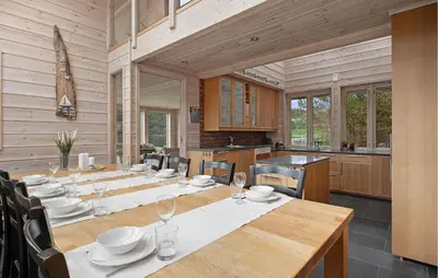a dining room with a long table and chairs at Sørkvingo in Masfjorden