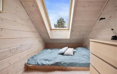 a small bed in a wooden room with a window at Sørkvingo in Masfjorden