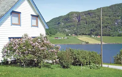 a white house with a lake and a mountain at Holiday Home Sørbøvåg Sandnes in Sandnes