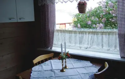 a dining room table with a white curtain and a window at Holiday Home Sørbøvåg Sandnes in Sandnes