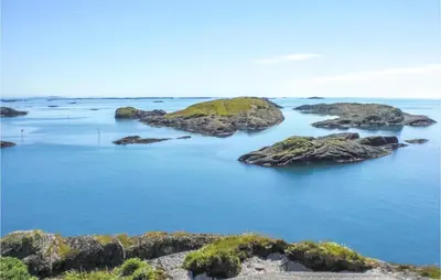 an island in the ocean with rocks in the water at Cozy Home In Lavik With House Sea View in Lavik