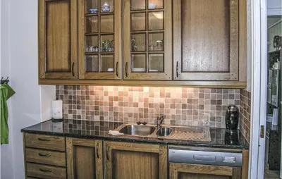 a kitchen with wooden cabinets and a sink at Gorgeous Home In Dalsøyra With Kitchen in Dalsøyra