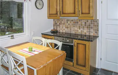a kitchen with a table and a stove top oven at Gorgeous Home In Dalsøyra With Kitchen in Dalsøyra