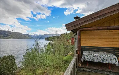 a bench sitting on the side of a building next to a lake at 2 Bedroom Beautiful Home In Balestrand in Balestrand