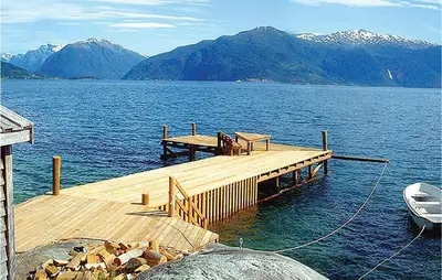 a dock with a boat on a large body of water at Holiday Home Balestrand Stokkebø Ii in Balestrand