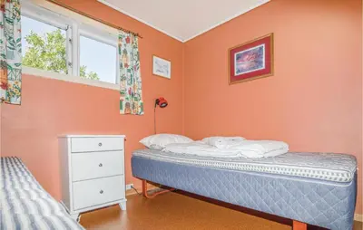 a bedroom with orange walls and a bed and a window at Holiday Home Balestrand Stokkebø Ii in Balestrand