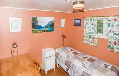 a bedroom with orange walls and a bed and a table at Holiday Home Balestrand Stokkebø Ii in Balestrand