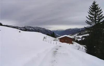 a snow covered road leading to a cabin on a mountain at Stunning Home In Vik I Sogn With Wifi in Espeset