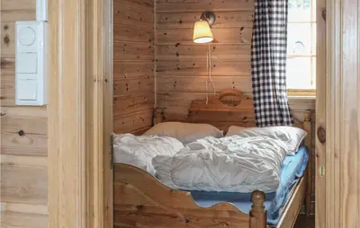 a small bed in a room with a wooden wall at Stunning Home In Vik I Sogn With Wifi in Espeset