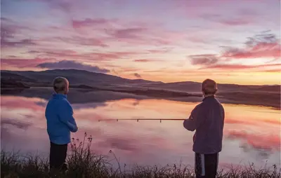 two men standing in front of a lake watching the sunset at Nice Home In Vik I Sogn With Jacuzzi in Åse