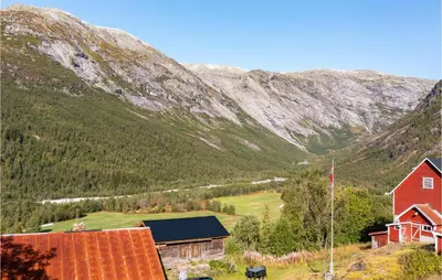 a red house in front of a mountain at Beautiful Home In Jostedal With Kitchen in Jostedal