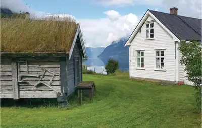 an old house and a barn in a field at Naddvik in Årdalstangen