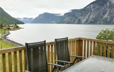 two chairs sitting on a deck with a view of a lake at Naddvik in Årdalstangen