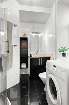a white bathroom with a washing machine in it at Central and quiet studio apartment in Ålesund in Ålesund