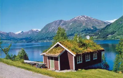 a small house with a grass roof next to a lake at Beautiful Home In Skei I Jølster in Årdal
