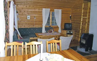 a living room with a table and a stove at Beautiful Home In Skei I Jølster in Årdal