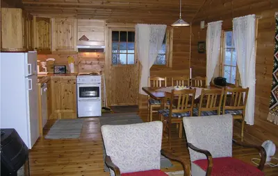 a kitchen and dining room with a table and a refrigerator at Beautiful Home In Skei I Jølster in Årdal
