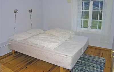 an unmade bed in a room with a window at Beautiful Home In Skei I Jølster in Årdal