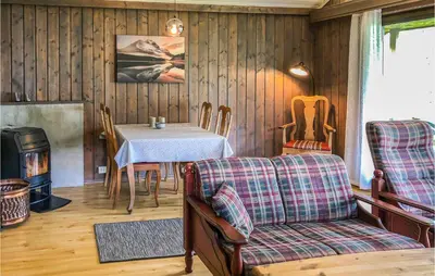 a living room with a table and a couch and a table and chairs at Gorgeous Home In Ålfoten With Sauna in Ålfoten