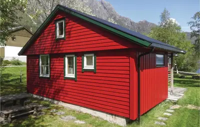 a red house with a bench in front of it at Gorgeous Home In Ålfoten With Sauna in Ålfoten