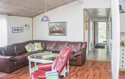 a living room with a leather couch and a table at Holiday Home Måløy Husevåg in Måløy
