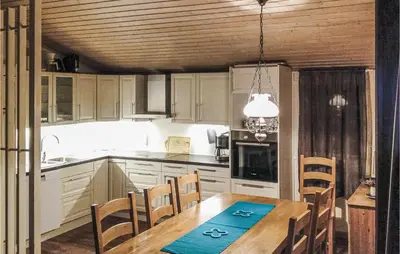 a kitchen with a wooden table and chairs and a dining room at Holiday Home Måløy Husevåg in Måløy