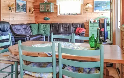 a dining room with a table and chairs and a couch at 3 Bedroom Awesome Home In Måløy in Måløy