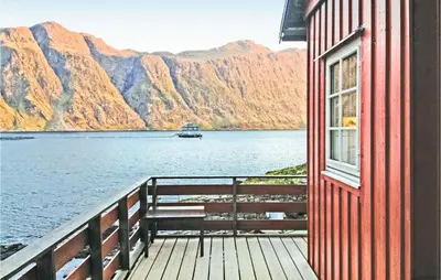 a building with a window and a boat in the water at 3 Bedroom Awesome Home In Måløy in Måløy