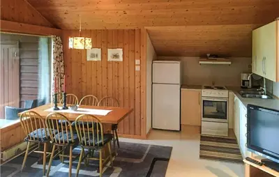 a kitchen with a table and chairs and a refrigerator at Flåten Hyttegrend in Olden