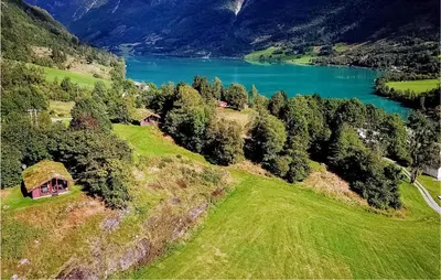 an aerial view of a house on a hill next to a lake at Flåten Hyttegrend in Olden